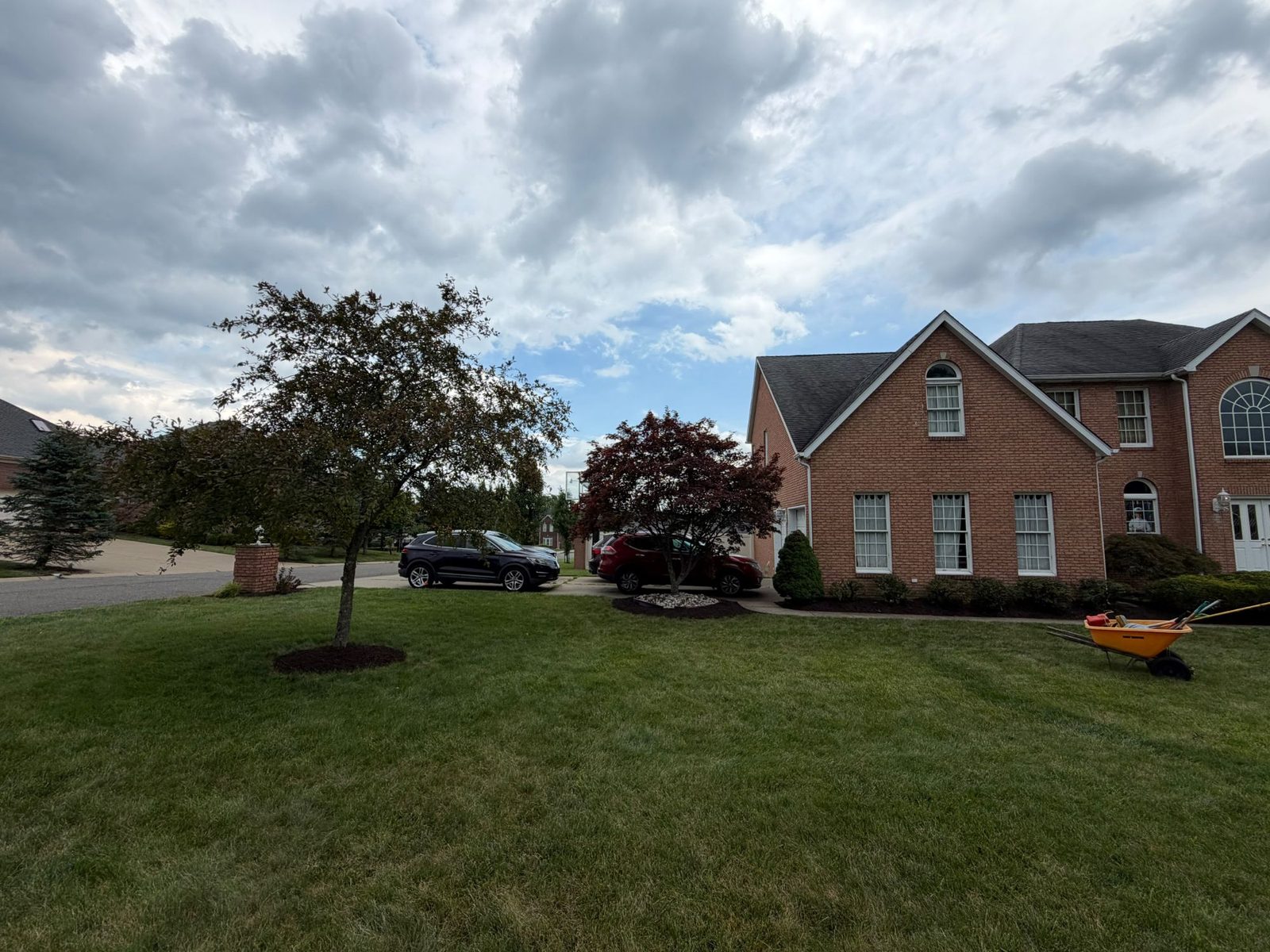 Residential property with finished landscaping and mulch beds along the driveway